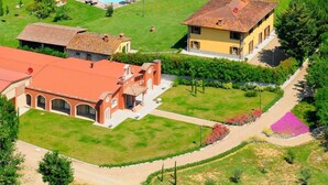 Una extensa propiedad con varias construcciones, piscina y jardines cuidados.