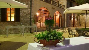 An outdoor dining area with stone walls, arched windows, and tables set for dining. - Beautiful private villa for 20 guests with private pool, WIFI, A/C, TV, patio and panoramic view (Gubbio)