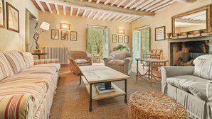 Un accogliente soggiorno con soffitto in legno, divani a righe, un tavolino da caffè e un camino.