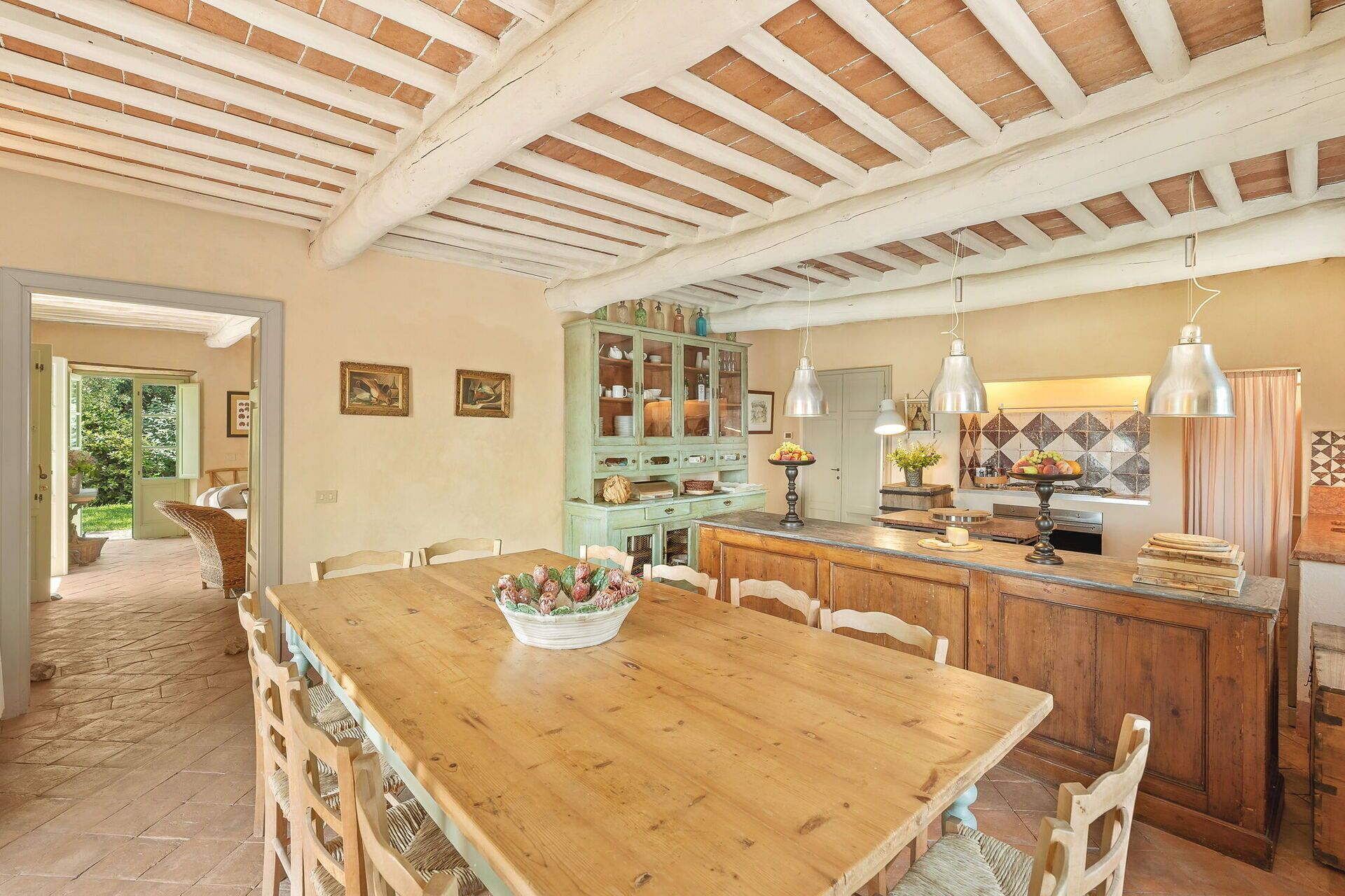 Une cuisine spacieuse avec une table à manger en bois, un îlot central intégré et un grand placard.