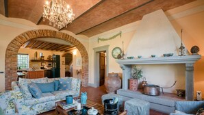 A cozy living room with a sofa, a coffee table, and a fireplace. - Stunning private villa for 12 people with A/C, WIFI, private pool, TV and panoramic view (Orentano)