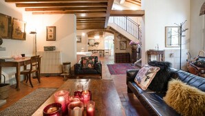 A spacious living area with a wooden ceiling, a fireplace, a dining table with chairs, and a leather sofa with decorative pillows. - Stunning private villa for 12 people with A/C, WIFI, private pool, TV and panoramic view (Orentano)