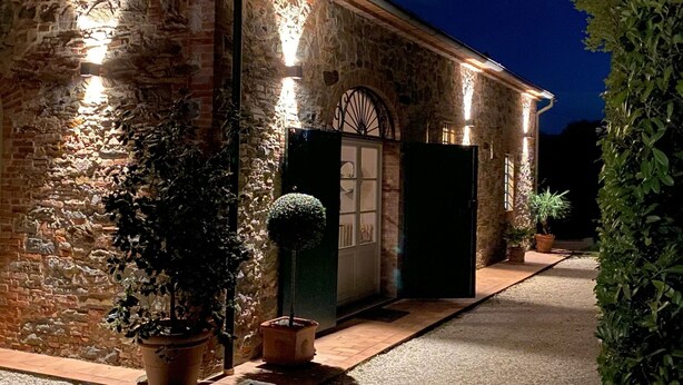 A stone building with a large open door and a small window, surrounded by potted plants and a pathway. - Stunning private villa for 12 people with A/C, WIFI, private pool, TV and panoramic view (Orentano)