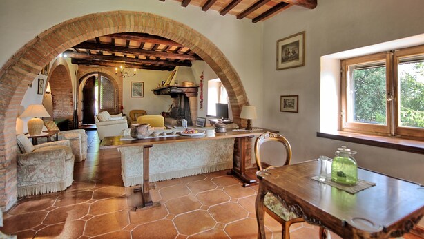 A rustic interior with exposed wooden beams, a stone fireplace, and a dining area with a table and chairs. - Beautiful private villa for 7 guests with private pool, A/C, TV and panoramic view (Cetona)