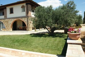 A house with a stone facade, a tiled roof, and an arched doorway.