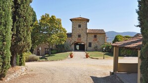 A stone building with a tower, a paved entrance, and a view of the surrounding landscape. - Nice apartment with pool, WIFI, TV, pets allowed and panoramic view, close to Greve In Chianti (Le Quattro Strade)