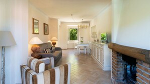 Una sala de estar con chimenea, comedor y cocina.