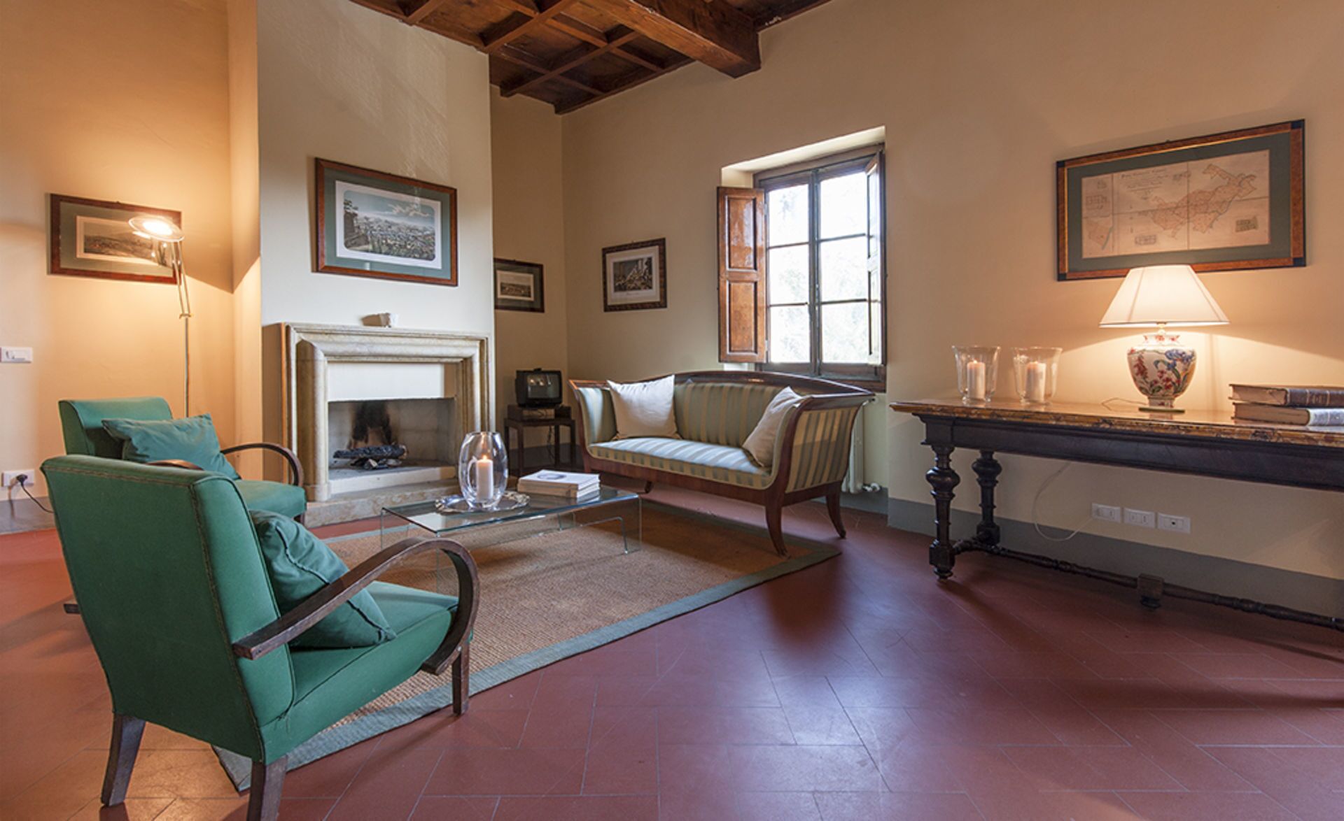 A cozy living room with a fireplace, green armchairs, a sofa, and a coffee table.