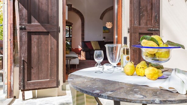 An open wooden door leading to a room with a table set with glasses, a bottle, and a bowl of lemons. - Beautiful private villa for 10 guests with private pool, A/C, WIFI, TV and pets allowed (Terranuova Bracciolini)