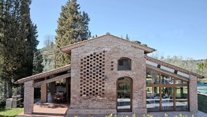 A modern house with a brick exterior, large windows, and a patio area. - Stunning private villa for 6 guests with private pool, WIFI, A/C, TV and panoramic view (San Miniato)