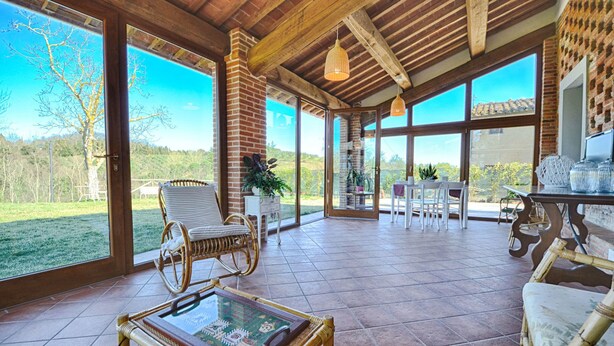A covered patio area with wicker furniture, a glass table, and a view of the outdoors. - Stunning private villa for 6 guests with private pool, WIFI, A/C, TV and panoramic view (San Miniato)