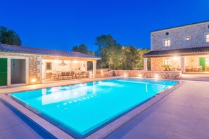 A swimming pool with a covered area and outdoor seating, surrounded by stone buildings with windows and doors. - SON FADRI - Villa with private pool in Campos. Free WiFi (Campos)