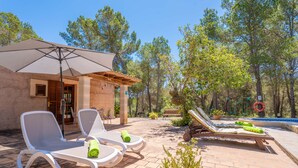 A patio with two lounge chairs, a table, and a large umbrella. - CASA MAS - Villa with private pool in Felanitx and free WiFi (Felanitx)