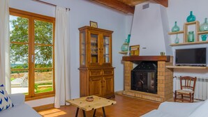 A living room with a fireplace, a television, and a view of the outdoors. - SON MORA - Villa with private pool in Porreres. Free WiFi (Porreres)