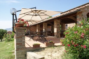 Relax in the serene patio area, surrounded by lush greenery and comfortable seating.