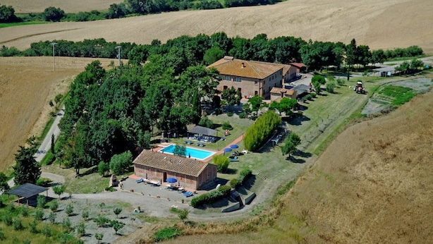 A rural property with a swimming pool, multiple buildings, and surrounding fields. - Cosy apartment in villa for 6 people with pool, WIFI, patio and panoramic view (Peccioli)