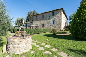 Traditional stone building with a symmetrical facade and well-manicured garden.