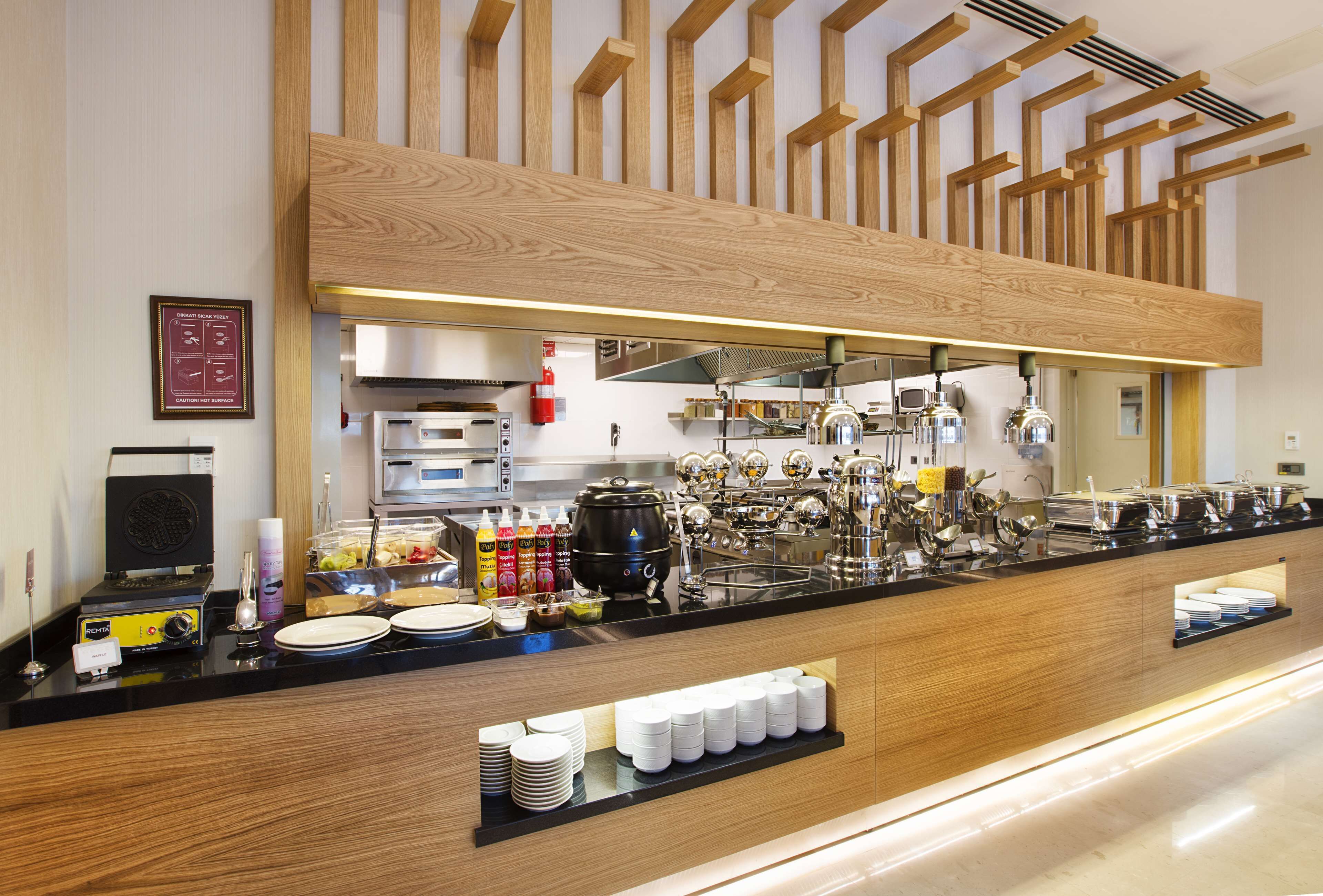 A modern kitchen with a wooden counter, stainless steel appliances, and a variety of food items and condiments.