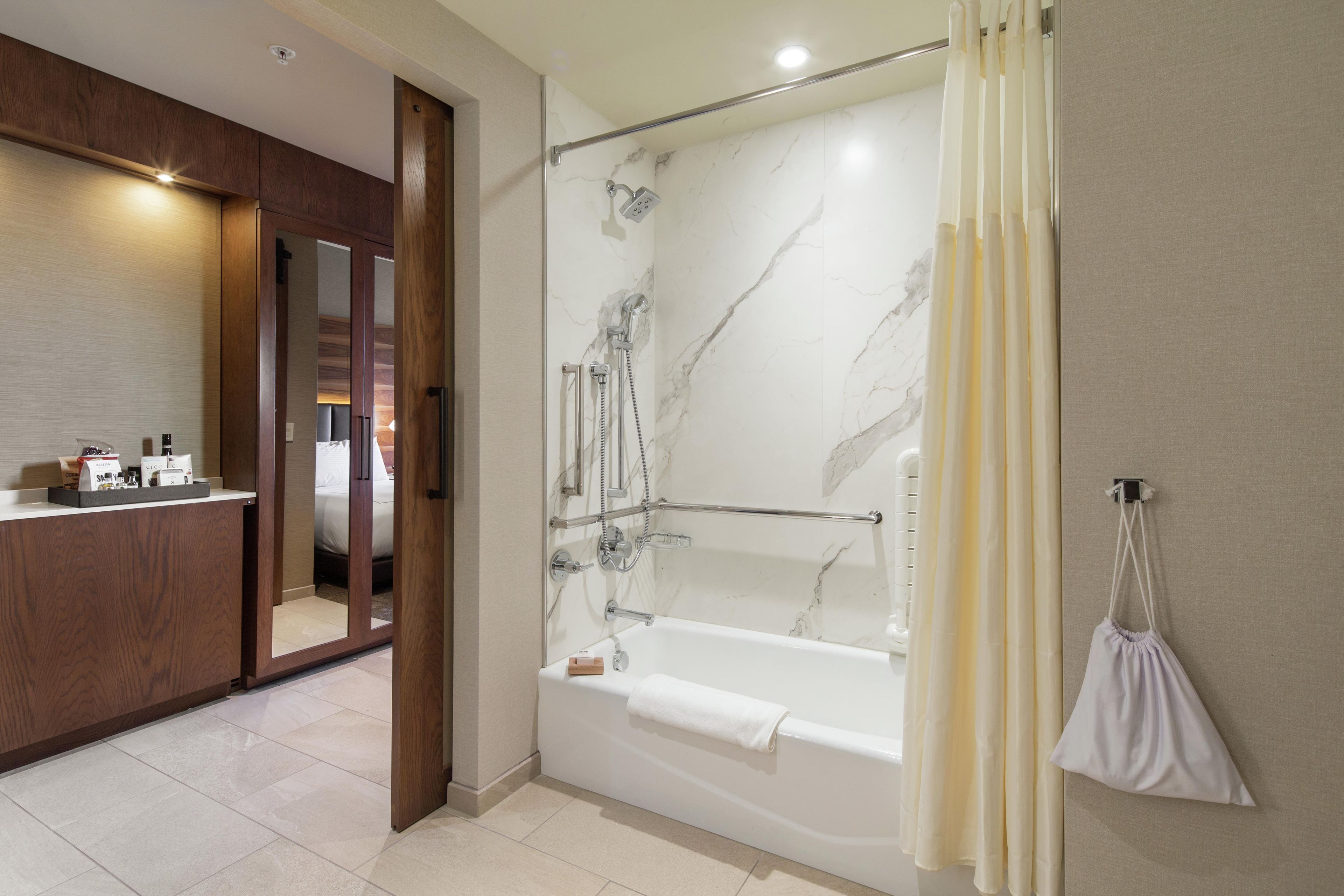 Une salle de bain moderne dotée d’une douche à l’italienne, d’une baignoire et d’un meuble-lavabo avec un miroir.