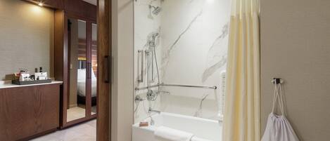 Une salle de bain moderne dotée d’une douche à l’italienne, d’une baignoire et d’un meuble-lavabo avec un miroir.