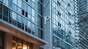 Edifici modern amb façana de vidre, un logotip prominent amb la lletra 'P' i el nom 'The Porter' a l'entrada.