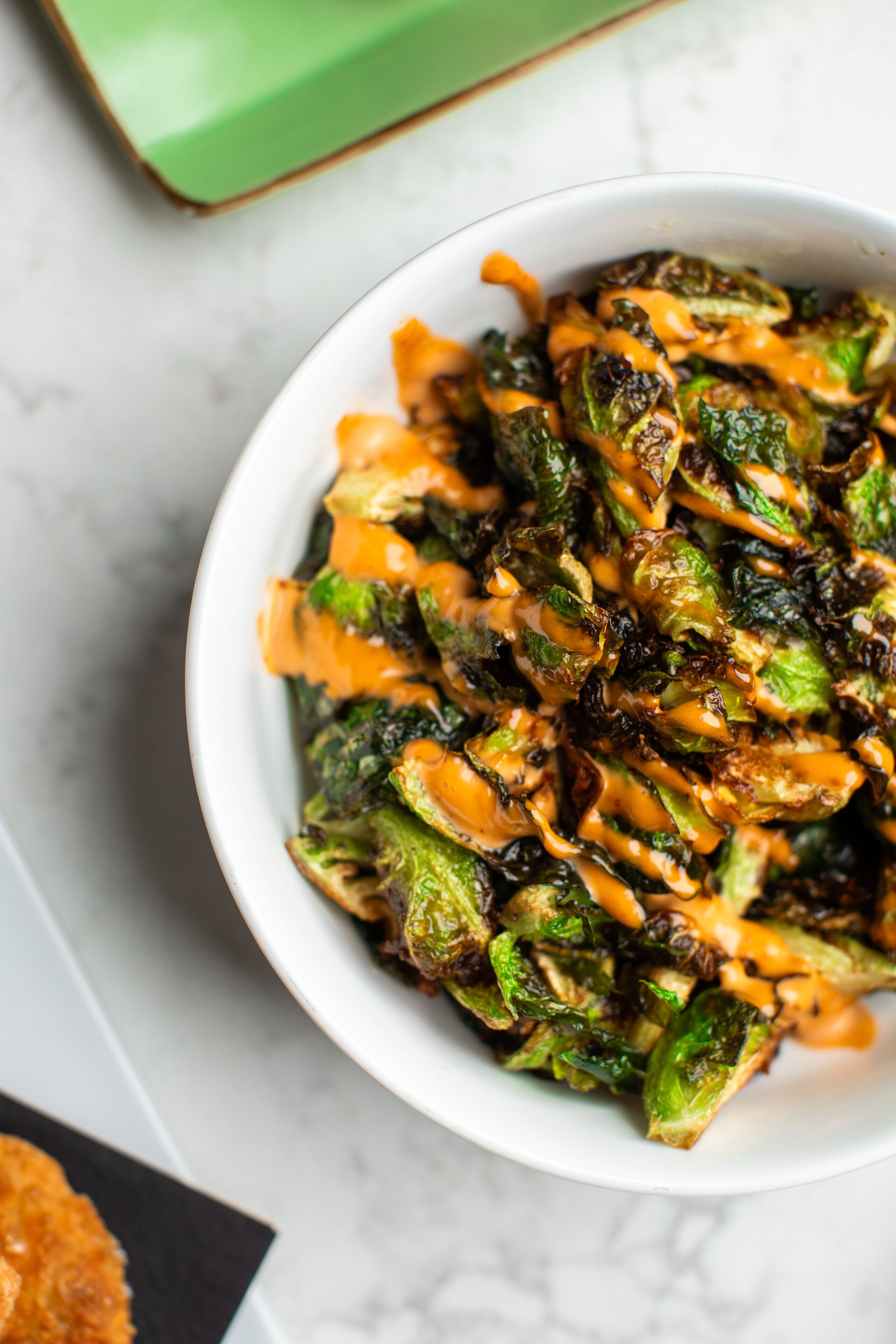 A bowl of Brussels sprouts with a sauce.