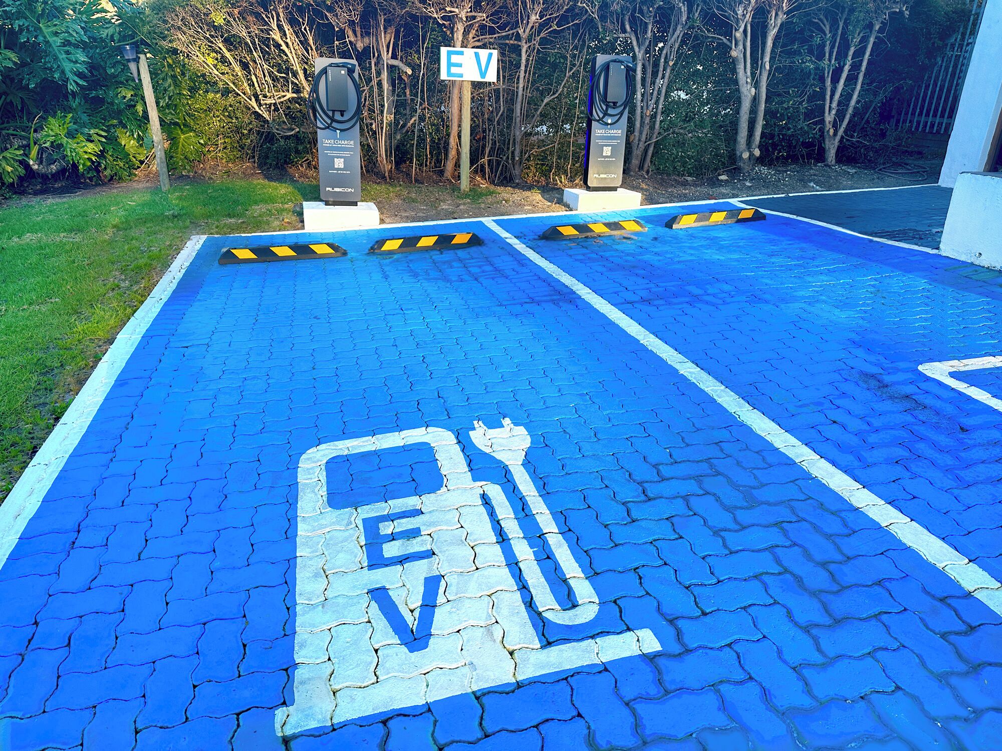 Eine Ladesäule für Elektroautos mit einem blau markierten Parkplatz.