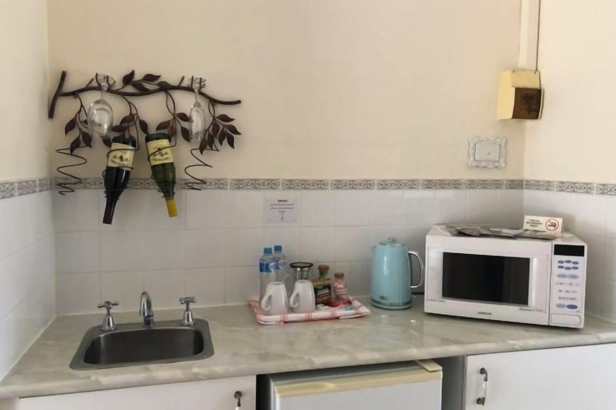 A kitchen with a sink, a microwave, and a decorative wall piece.