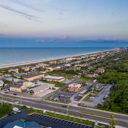 Stunning coastal town with beachfront views, residential homes, commercial establishments, and a scenic green space.