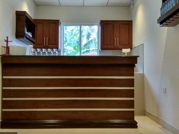 A kitchen with wooden cabinets and a central island. - Diva Villa Transit Hotel (Seeduwa - Katunayake)