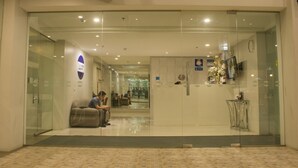 A modern hotel lobby with a glass entrance, seating area, and a reception desk. - 1A Express Hotel (Cagayan de Oro)