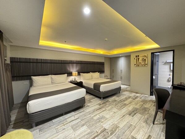 A modern hotel room with two beds, a desk, and a chair. - 1A Express Hotel (Cagayan de Oro)