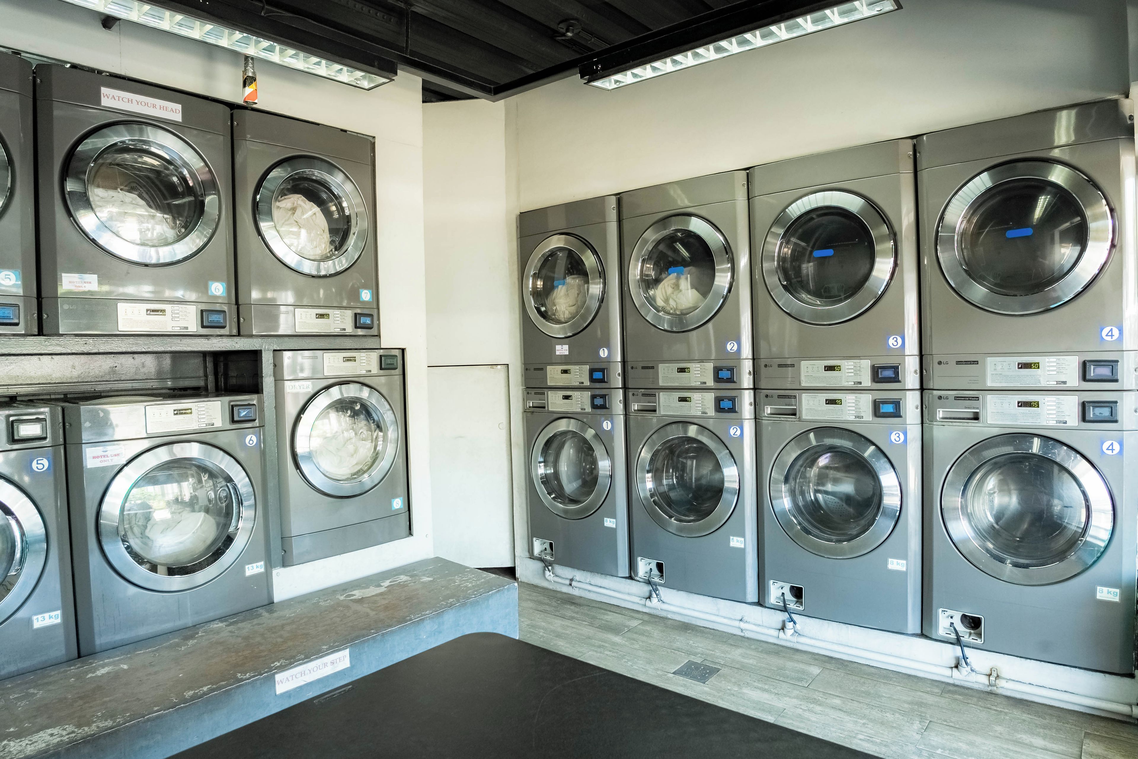A row of commercial laundry machines in a facility.