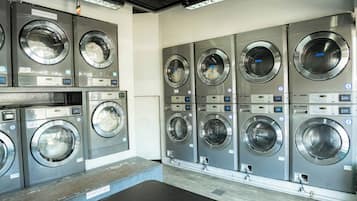 A row of commercial laundry machines in a facility.