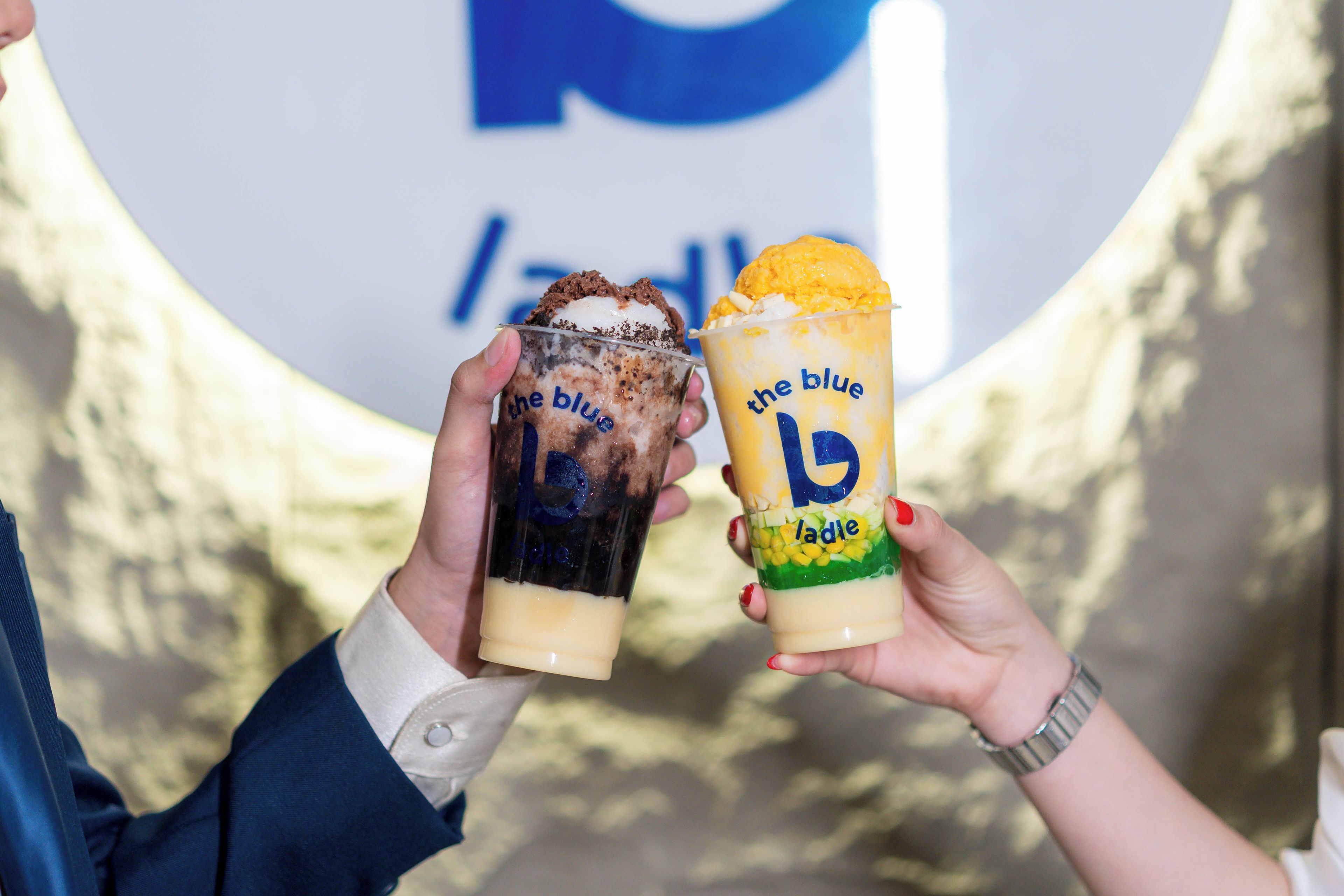 To personer holder isdesskeer med 'the blue lady' branding.