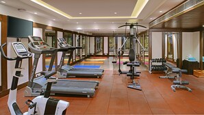 Ein Fitnessstudio mit Laufbändern, Crosstrainern und Gewichten.