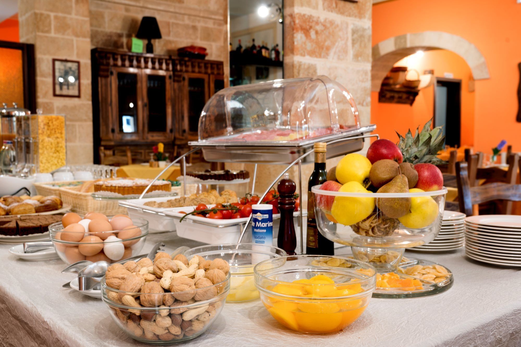 Un bufé con diversas opciones de comida, incluyendo frutas, frutos secos y pasteles.
