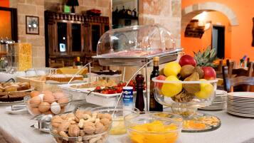Un bufé con diversas opciones de comida, incluyendo frutas, frutos secos y pasteles.
