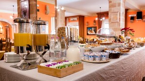 A buffet setup with various food items, beverages, and a juice dispenser. - Hotel Salento (Specchia)