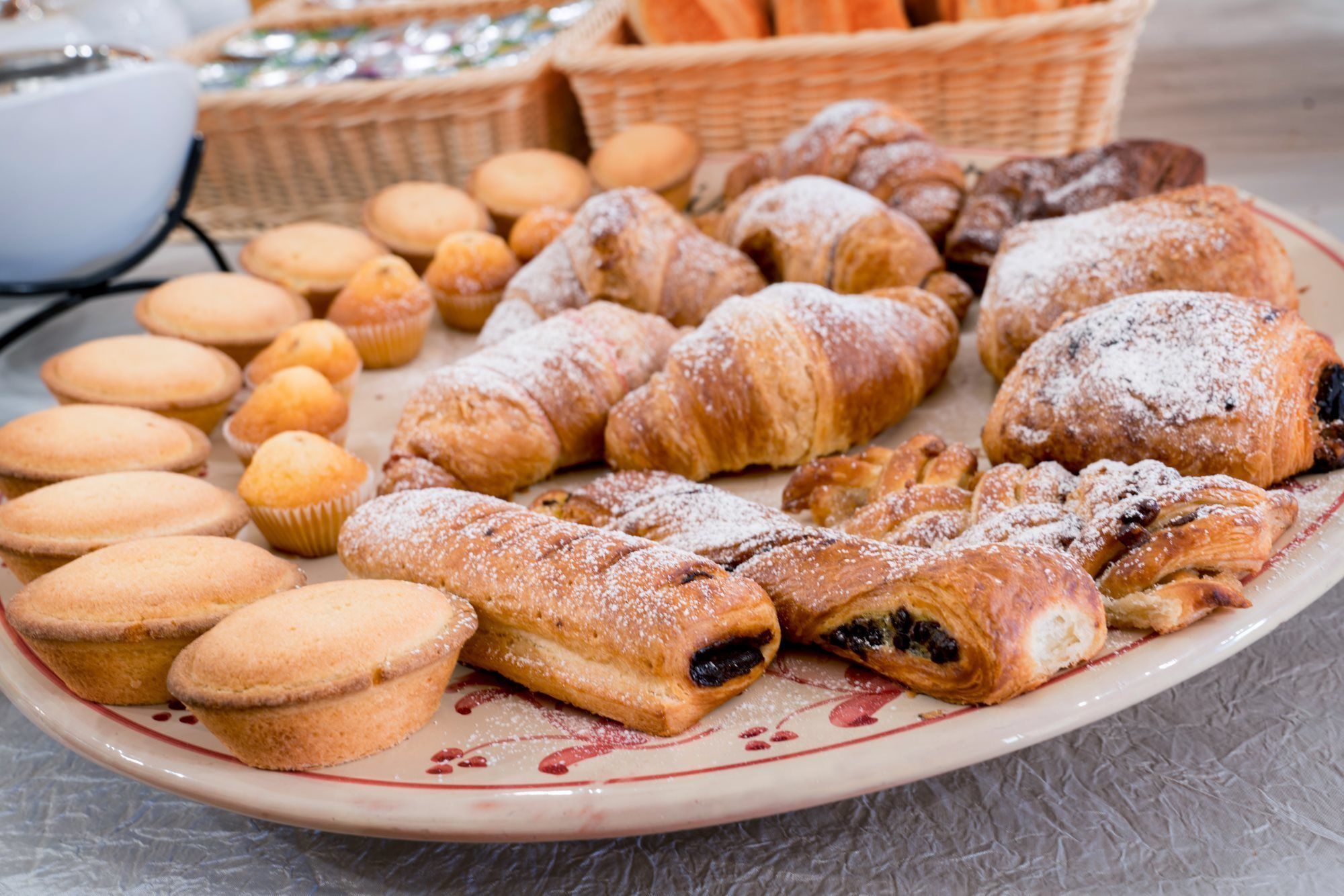 Una variedad de productos horneados, como muffins, croissants y pasteles, sobre un plato.