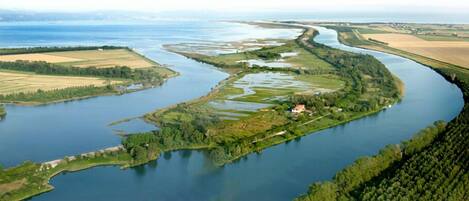 An aerial view of a river meandering through a landscape with fields and a small settlement.