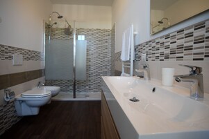 Habitación triple Deluxe | Baño | Ducha y cabezal de ducha tipo lluvia