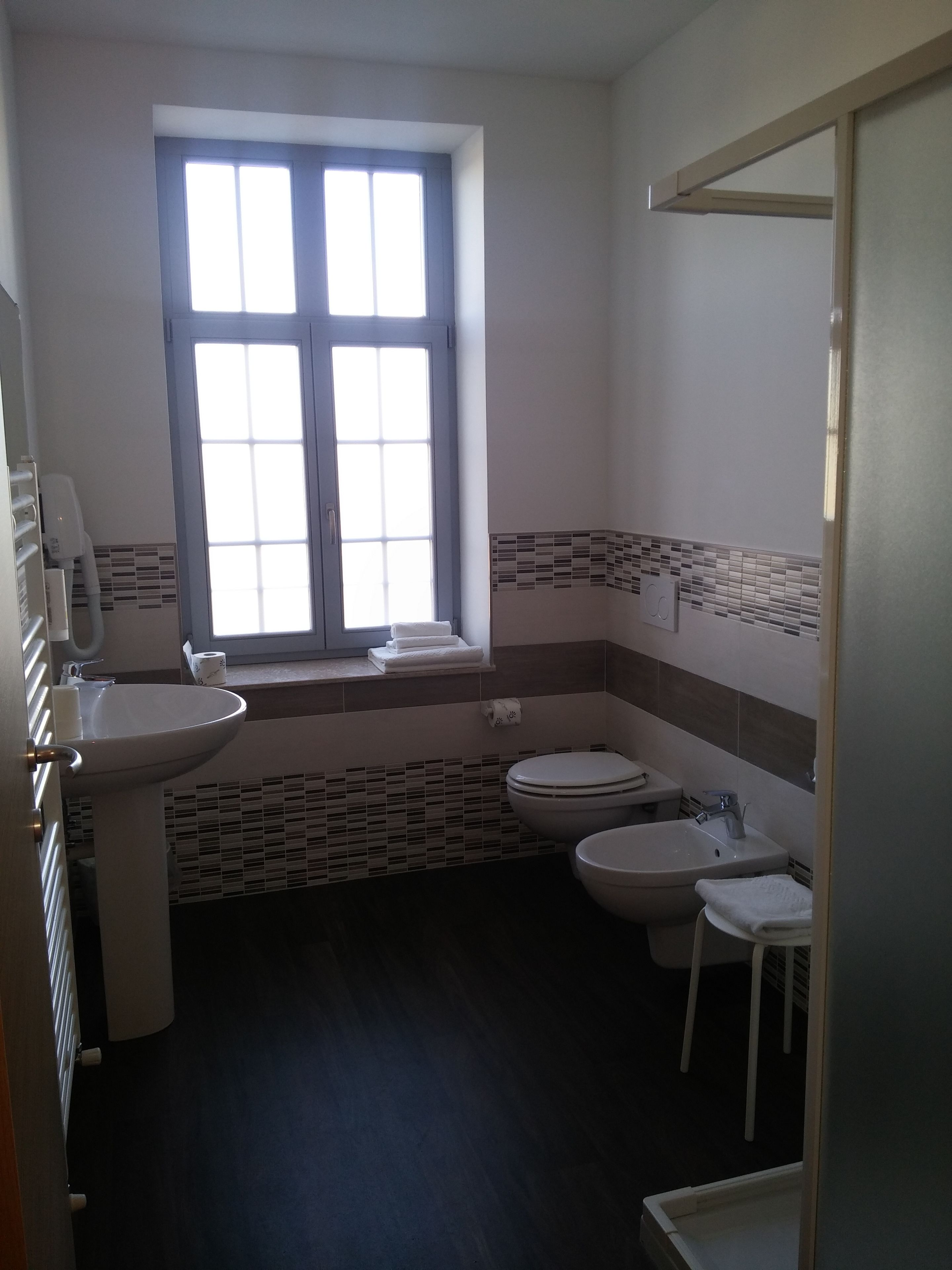 Un baño con ventana, lavabo, inodoro y bidé.
