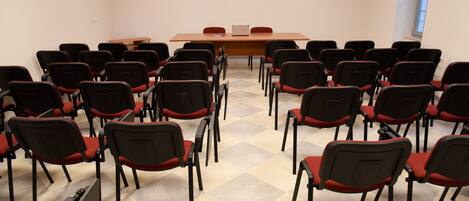 A conference room with a long table and rows of chairs.