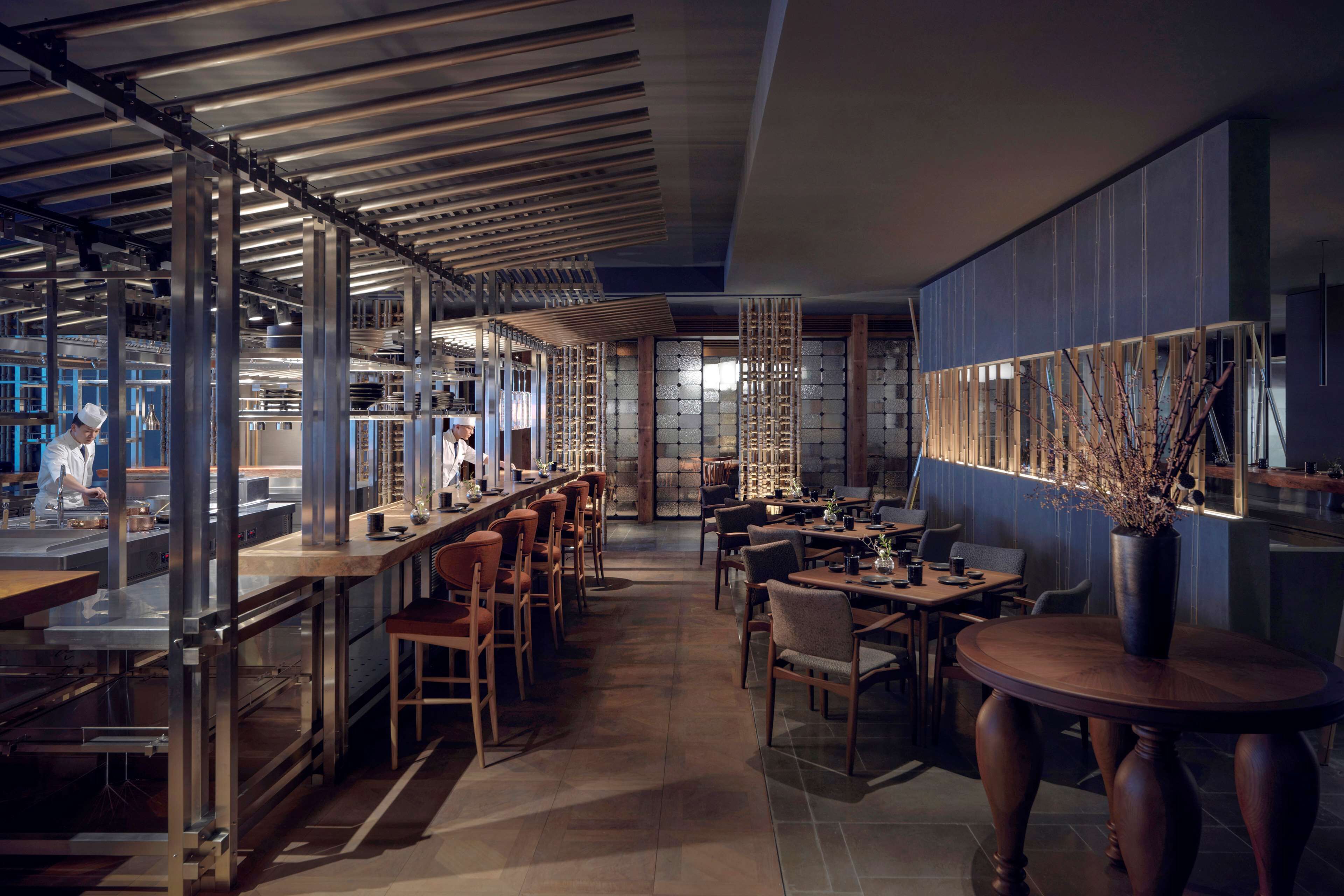 Un restaurante moderno con una barra larga, varias mesas y una zona de bar.