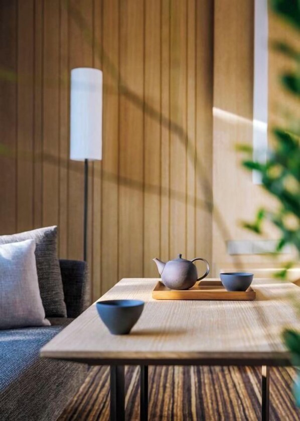 A modern living room with a wooden table, a sofa, and a floor lamp. - Hyatt Regency Beijing Wangjing (Beijing)