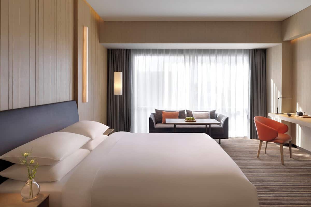Una habitación de hotel con una cama grande, un sofá, un escritorio y una silla.