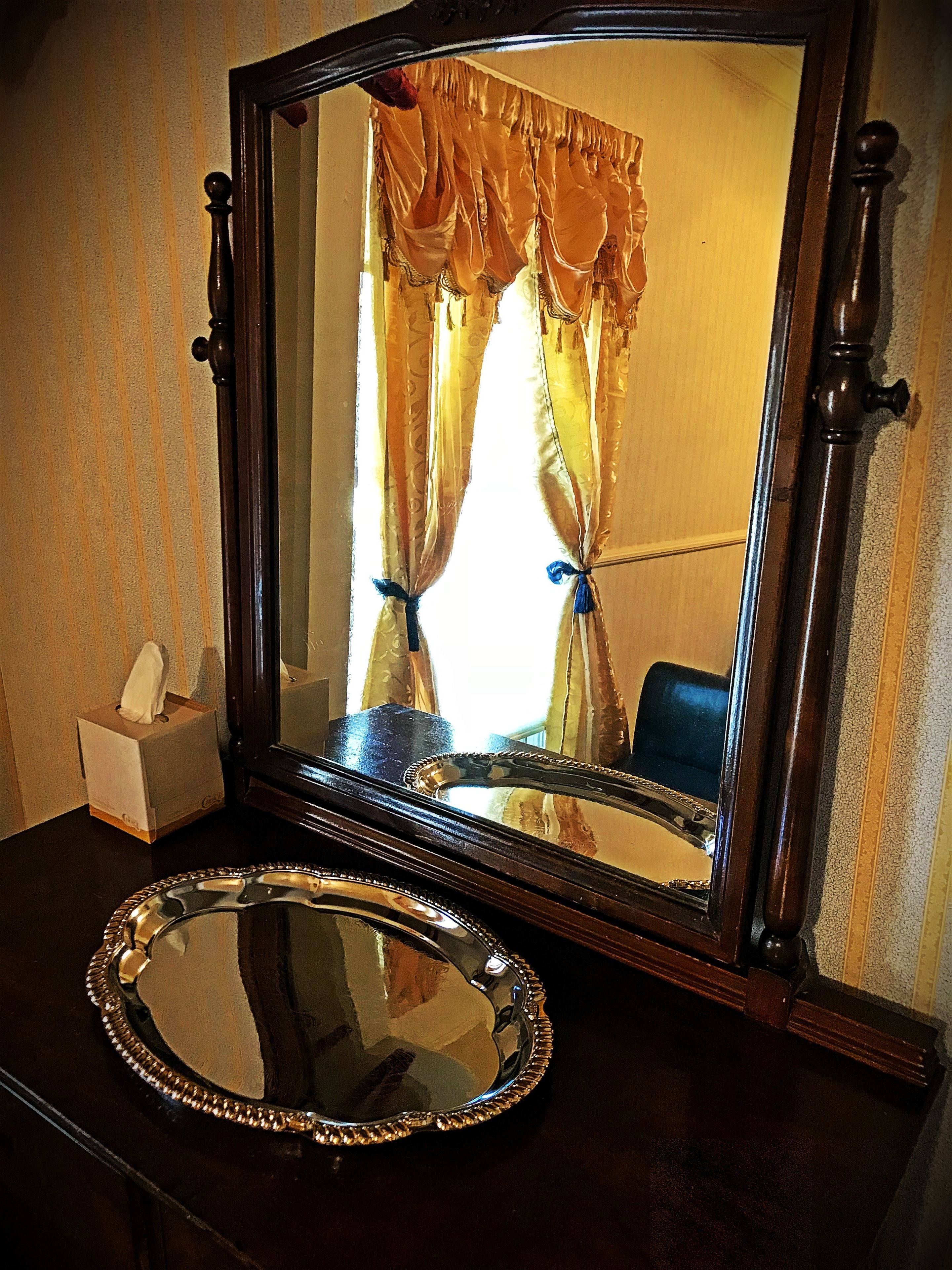 A mirror with a decorative frame on a wooden surface.