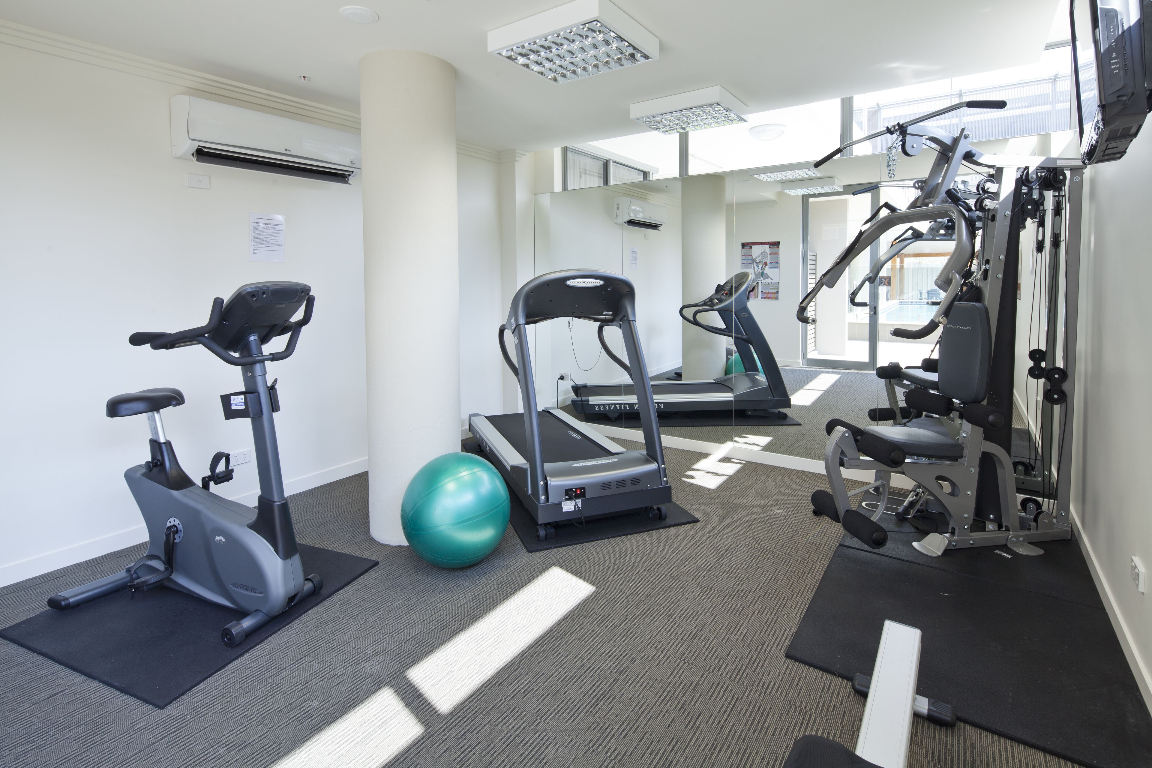 Un gimnasio con bicicletas estáticas, cintas de correr y máquinas de pesas.