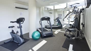 Un gimnasio con bicicletas estáticas, cintas de correr y máquinas de pesas.
